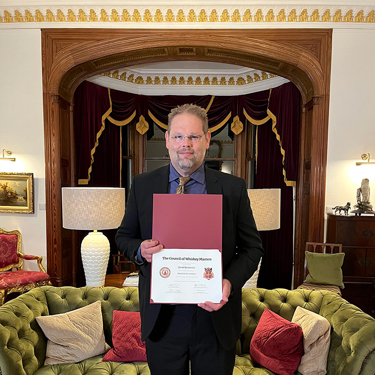 photo of Jerad Justesen – taken in Scotland – holding his Master of Scotch certificate